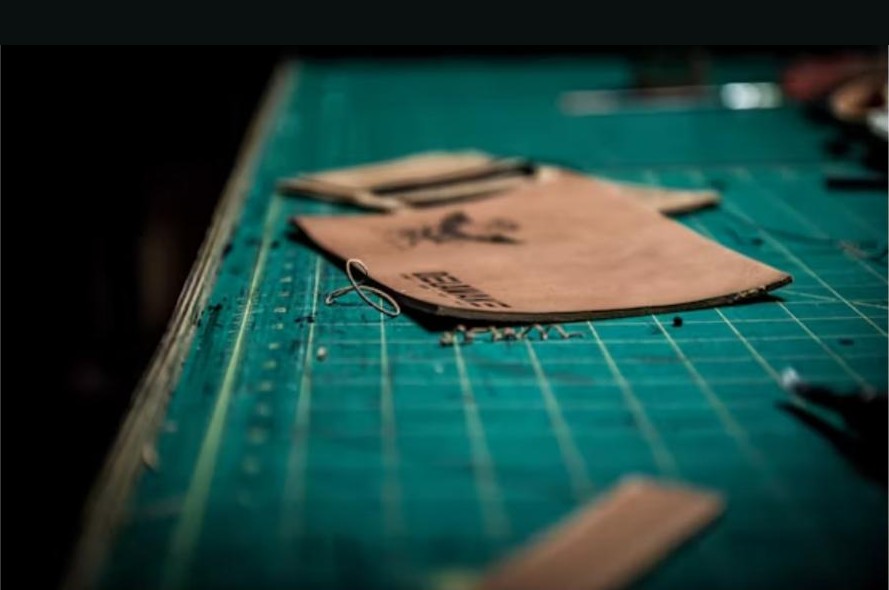 Leather panel being cut and marked on a workshop table
